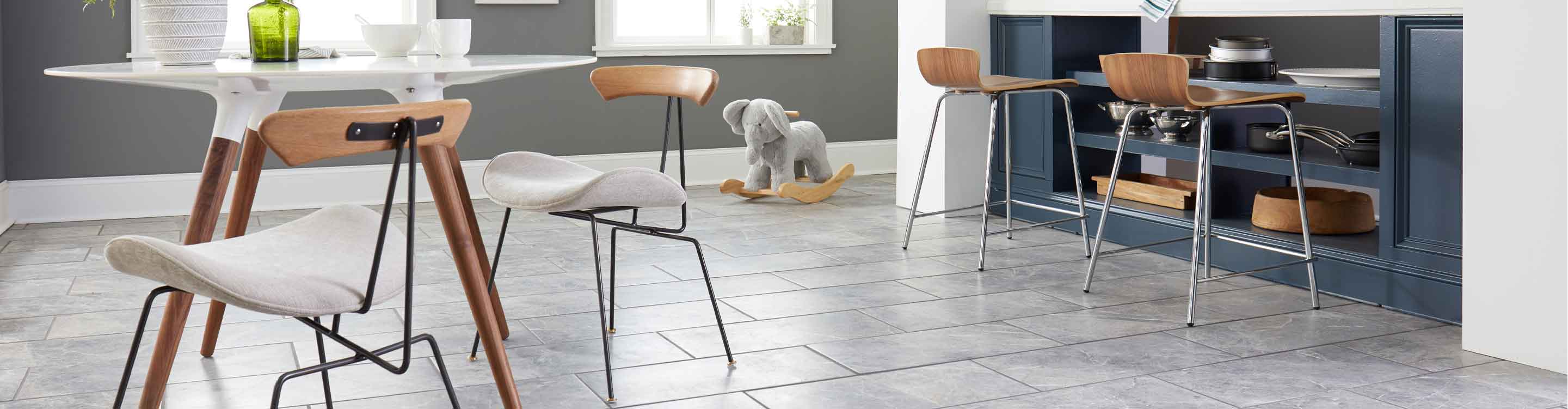 gray marble tile in kitchen with blue island, white kitchen table and wood accents